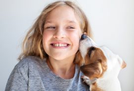Happy child with dog. Portrait girl with pet. Jack Rassell whispers a secret to teen